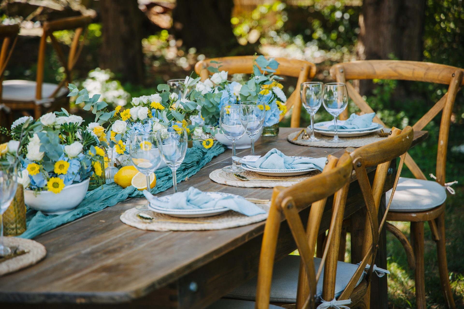 Dressage de table en extérieur avec compositions florales et citrons.