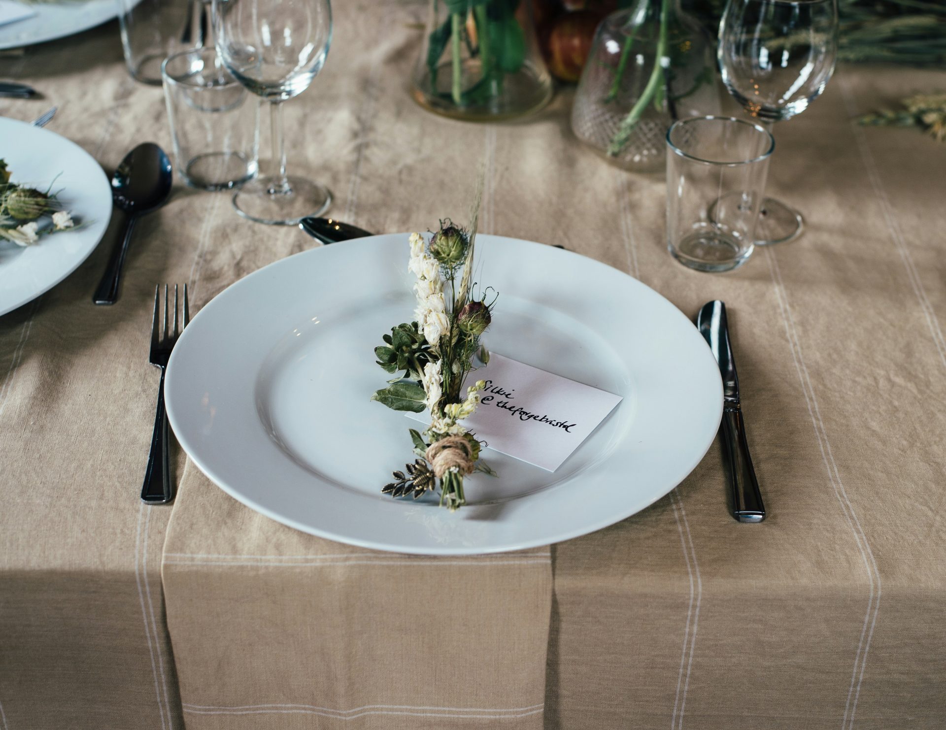 fleur décorative verte et blanche sur une assiette blanche et couverts sur la table